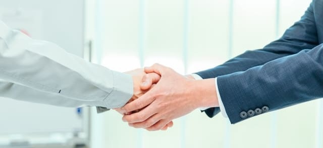 電話対応の前に料金条件や作業内容を見える化して安心されたお客様と握手するイメージ