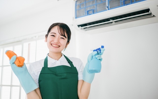 エアコン掃除で節電する笑顔の女性
