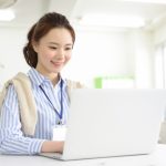 ノートパソコンで仕事をする女性社員のイメージ画像